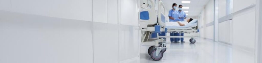 Hospital bed with medical castor wheels in a healthcare corridor, ensuring smooth, safe movement for patient transport | Rexello Castors